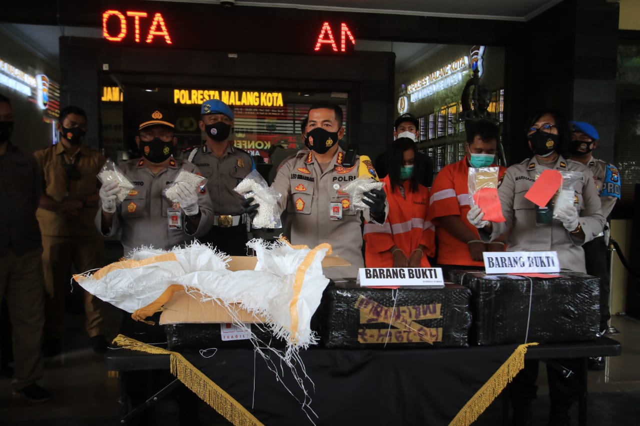 Dua tersangka pengedar narkoba dan barang bukti berupa pil koplo sebanyak lebih dari 2 juta butir (Laoh Mahfud / Radar Malang)