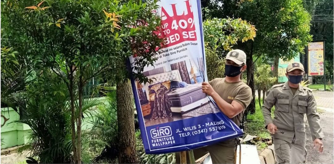 Petugas Satpol PP saat menyita reklame liar di Jalan Soehat beberapa waktu yang lalu. ( Satpol PP Kota Malang for Radar Malang).