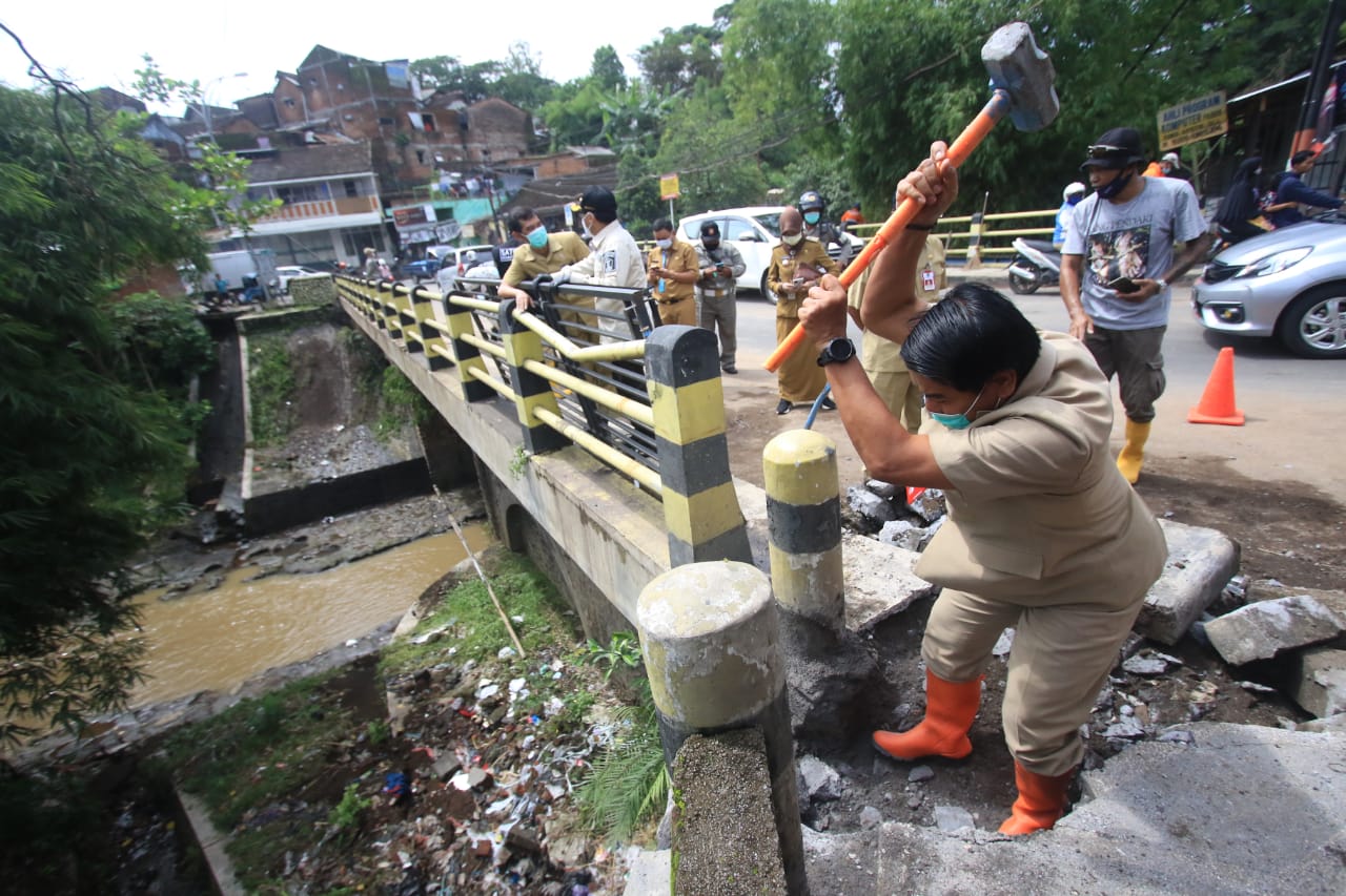 Sekda Kota Malang, Wasto menjebol sumbatan yang menghalangi saluran air di Jembatan Bandulan, Kota Malang (Laoh Mahfud / Radar Malang)