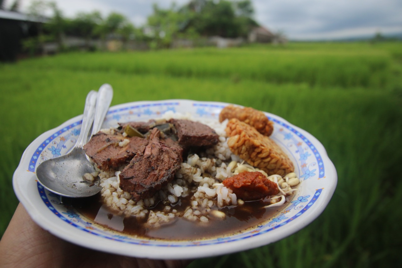 Menikmati rawon di tengah sawah akan memberikan sensasi kenikmatan yang berbeda (Darmono / Radar Malang)