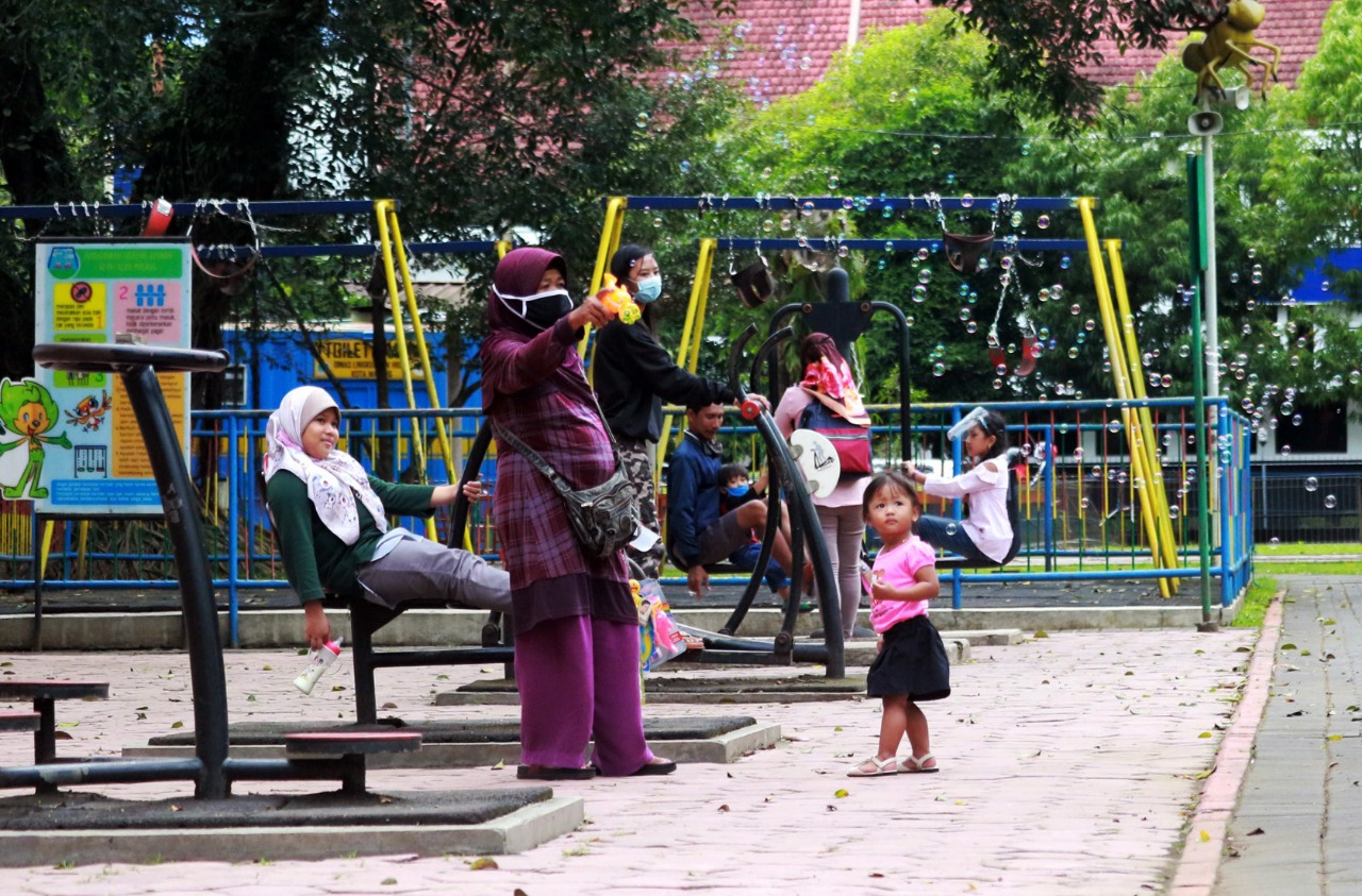 Sejumlah warga tetap menerobos pagar Alun-Alun Kota Malang meski ada pengumuman larangan masuk taman. (Laoh Mahfud/Radar Malang)