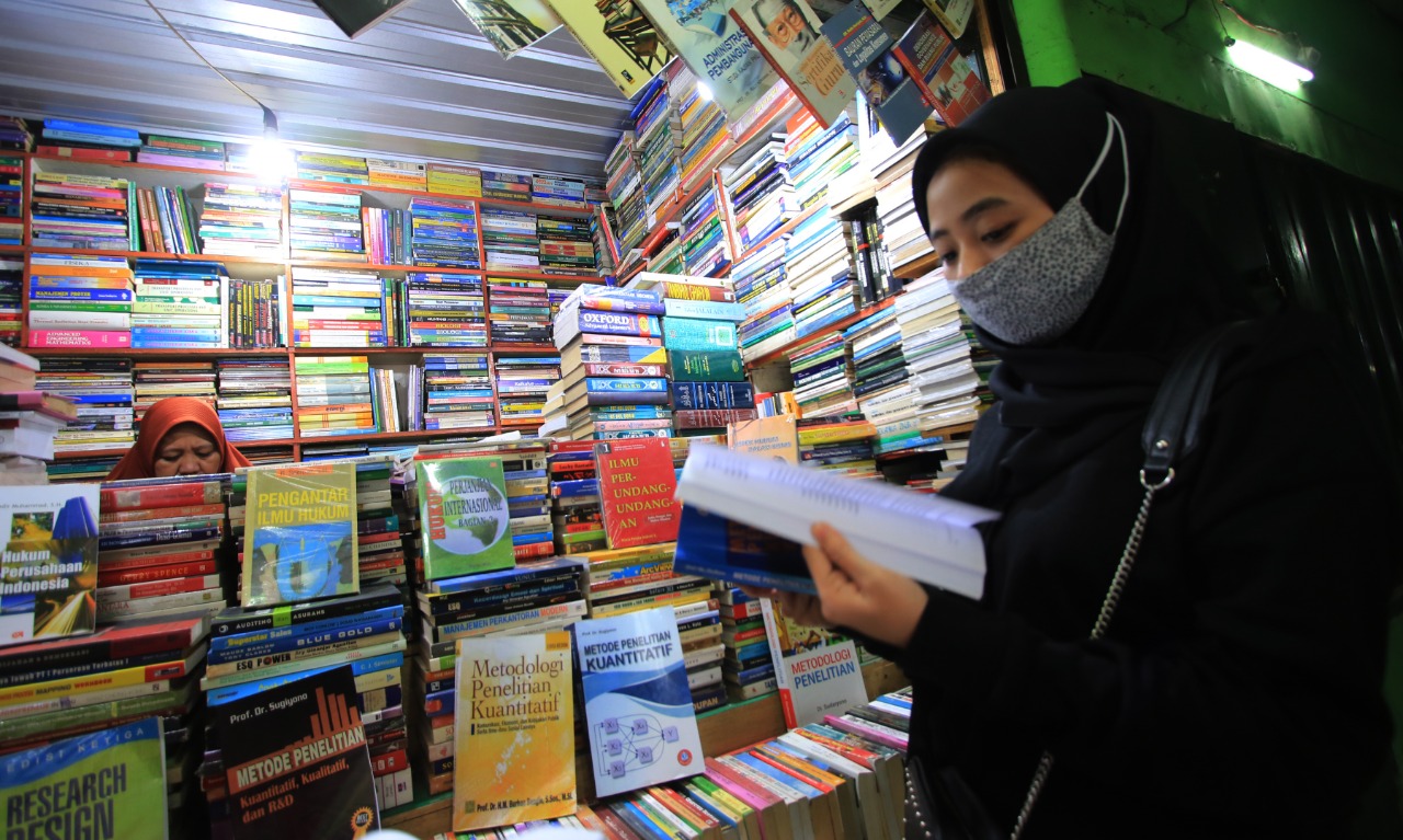 Pengunjung sedang melihat-lihat buku di Pasar Buku Wilis, Kota Malang. Selama pandemi, jumlah pengunjung terus turun. (Laoh Mahfudz/Radar Malang)