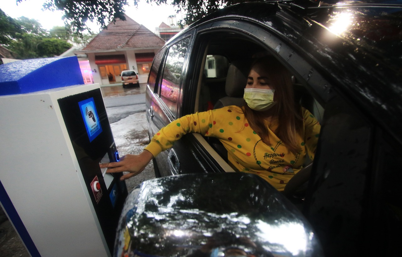 Pengguna kendaraan mengambil tiket e-Parkir di kawasan Stadion Gajayana. (Laoh Mahfud/Radar Malang)