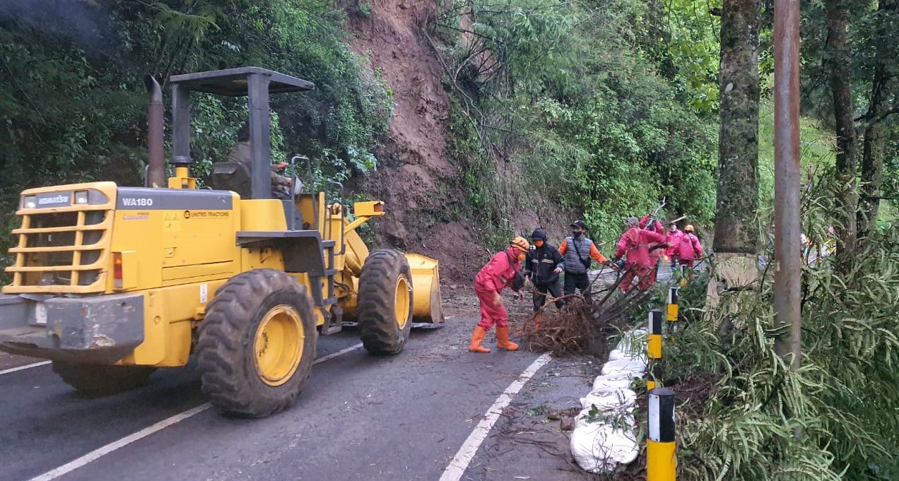 Petugas berusaha menyingkirkan sisa material longsor  di kawasan Payung Kota Batu tadi pagi (18/1). (BPBD Kota Batu for Radar Malang).
