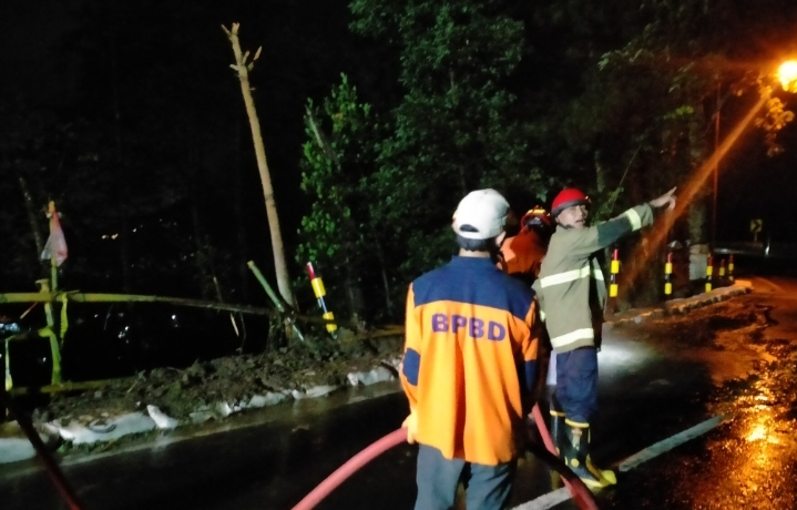 Tim reaksi cepat BPBD Kota Batu saat membersihkan material longsor di Payung, tadi malam (16/1). (BPBD Kota Batu for Radar Malang)