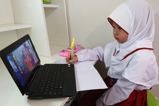 Ilustrasi salah satu siswa sekolah dasar sedang belajar secara daring. (dok/Radar Malang)