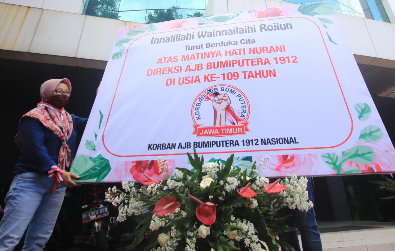 Nasabah menaruh papan karangan bunga duka cita di kantor AJB Bumiputera 1912 (Laoh Mahfud / Radar Malang)