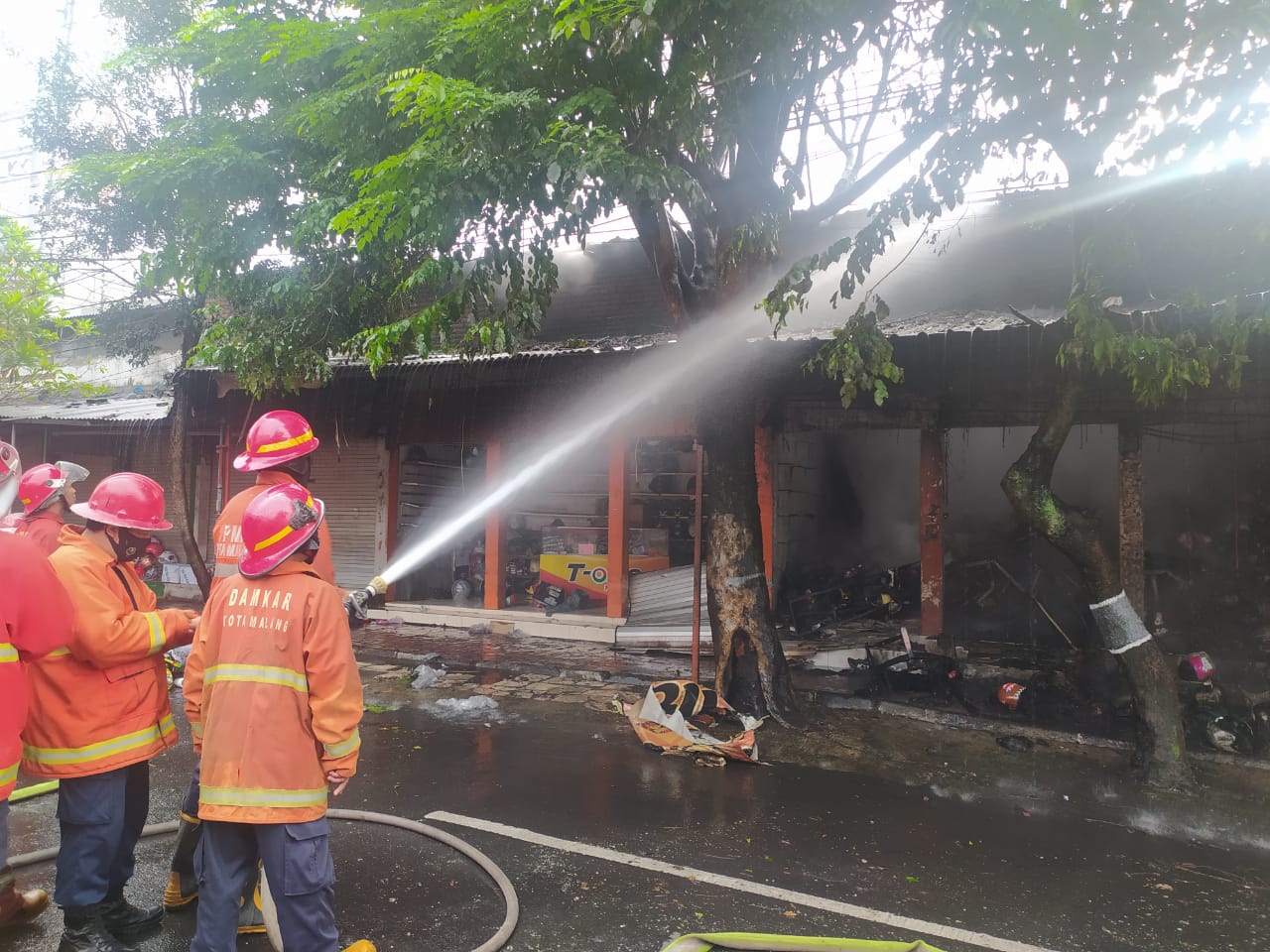 Proses pemadaman kebakaran di toko helm Stasiun Kota Malang (Laoh Mahfud / Radar Malang)