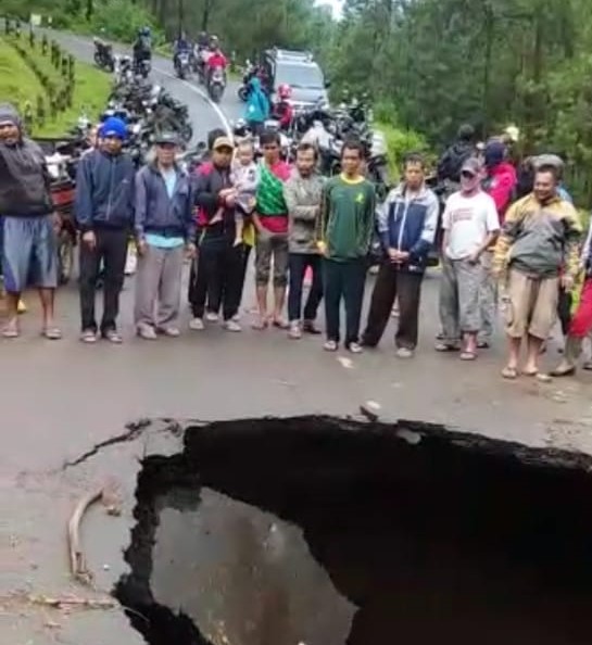 Screenshot video warga berkerumun di dekat aspal jalan yang ambles. (laoh mahfud/radar malang)