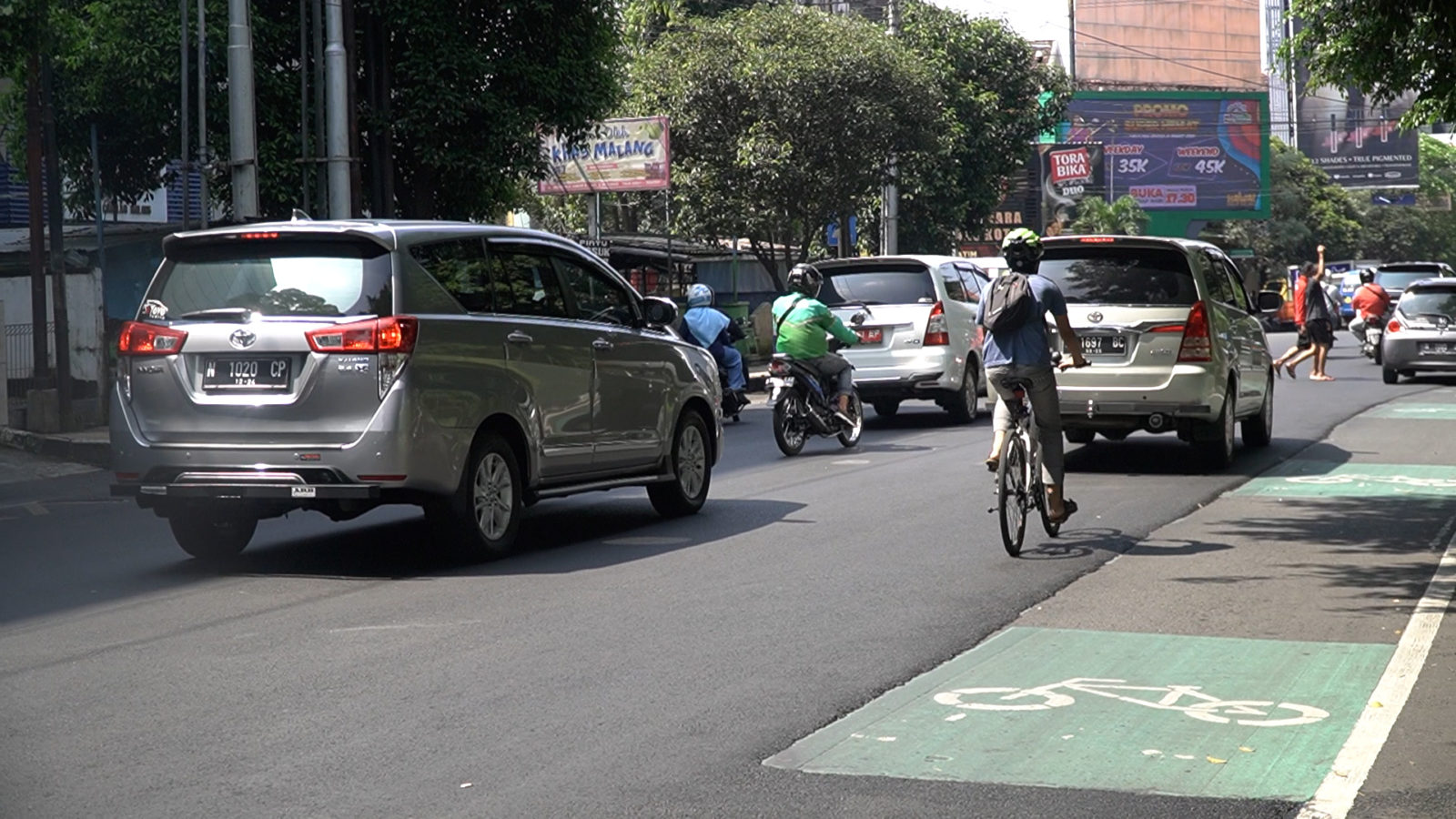 Perbaikan aspal jalan yang hanya sampai di sisi luar jalur sepeda di timur Alun-Alun Kota Malang ini jadi sorotan. (Fuad/Radar Malang)