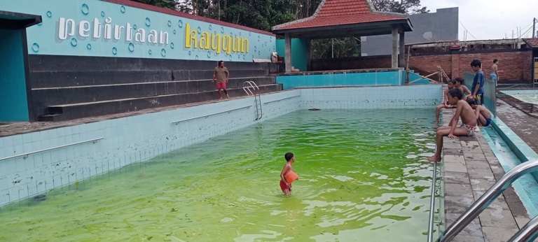 Sejumlah bocah asyik bermain di kolam renang wisata Petirtaan Kaygun, Desa Tlekung, Kecamatan Junrejo, Kota Batu, beberapa waktu lalu. Hingga kini wisata itu belum dibuka untuk umum. (Nugraha Perdana/Radar Malang)