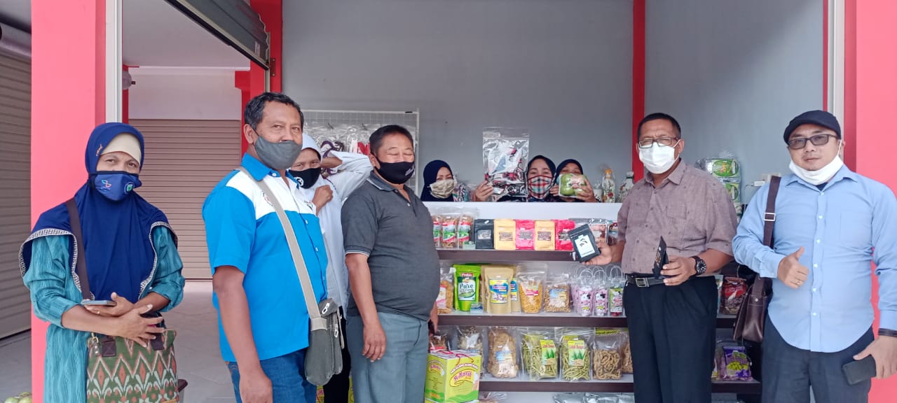 Kepala Dinas Koperasi, Usaha Mikro, Perindustrian, dan Perdagangan Eko Suhartono dan Kepala Desa Sidomulyo Suharto berfoto bersama di salah satu kios Pasar Sidomulyo.