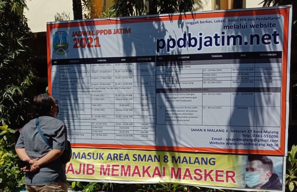 LEBIH KETAT: Orang tua murid sedang melihat pengumuman tahapan PPDB SMA/SMK. (Aditya Novrian/Radar Malang)