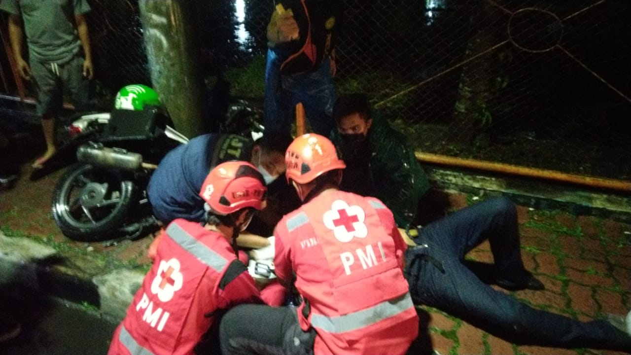 Petugas PMI dibantu warga saat mengevakuasi ojol yang mengalami luka-luka setelah tertabrak mobil di Jalan Sarangan, Kota Malang. (PMI Kota Malang/ist)