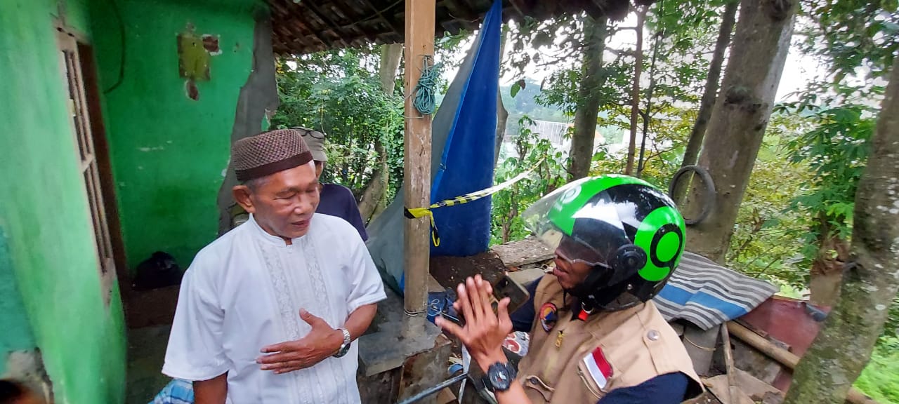 Rahman (kiri) di dekat anaknya yang amblas ke sungai yang dipasangi pita kuning di bagian depannya. (Biyan Mudzaky/Radar Malang)