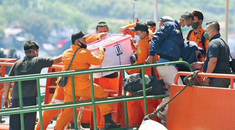 Anggota tim SAR memasukkan alat-alat untuk evakuasi kapal selam ke dalam kapal yang melacak KRI Nanggala-402. (RAMADA KUSUMA/JAWA POS RADAR BANYUWANGI/ist)