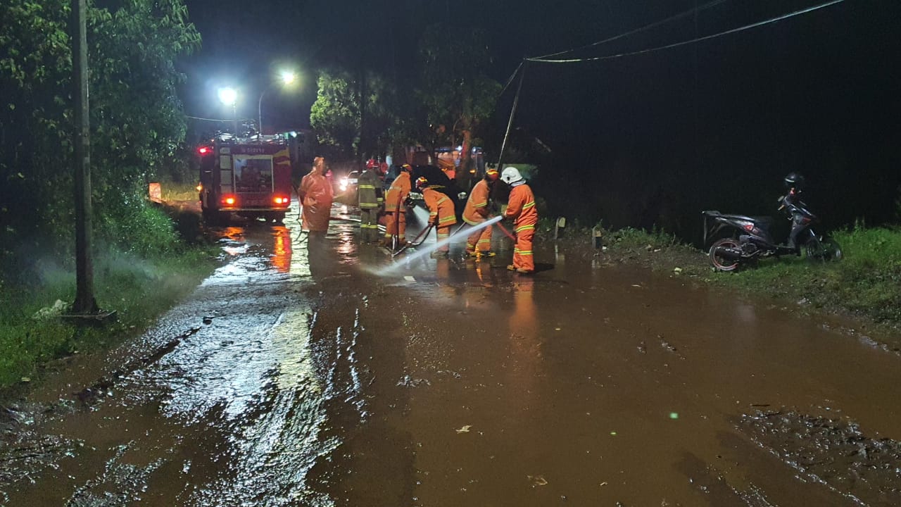 Petugas bersama warga saat membersihkan material lumpur yang menutupi Jalan Raya Sumberbrantas. (BPBD Kota Batu/ist)