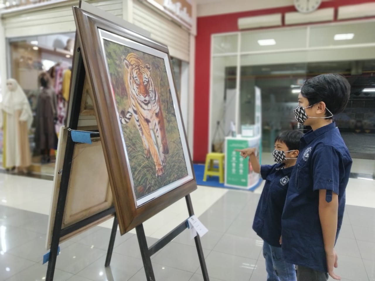 Pengunjung Mall Matos menikmati lukisan yang dipamerkan di lantai II. (Intan Refa/Radar Malang)