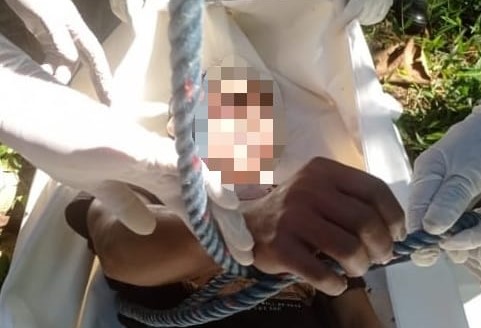 Petugas saat mengevakuasi jenazah korban dari atas pohon kelapa setinggi 20 meter. (Relawan Malang Raya for Radar Malang)