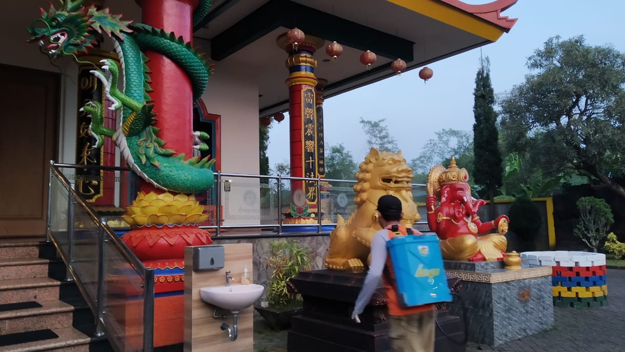 Penyemprotan vihara sebelum dipakai untuk beribadah Hari Raya Waisak yang dirayakan besok, Rabu (26/5) (Intan Refa / Radar Malang)