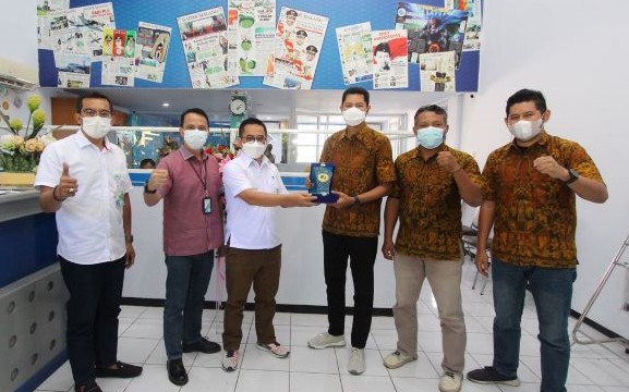 Anggota Dewas BPJS Ketenagakerjaan Yayat Syariful Hidayat (tiga dari kiri) menyerahkan cinderamata kepada GM Jawa Pos Radar Malang Don Virgo saat kunjungan ke kantor Jawa Pos Radar Malang Jumat (4/6). (Rofiah/Radar Malang)