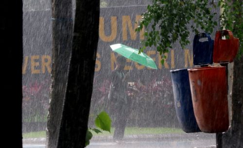 Warga menggunakan payung saat hujan turun cukup deras di Jalan Jakarta, Kota Malang. (Darmono/Radar Malang)