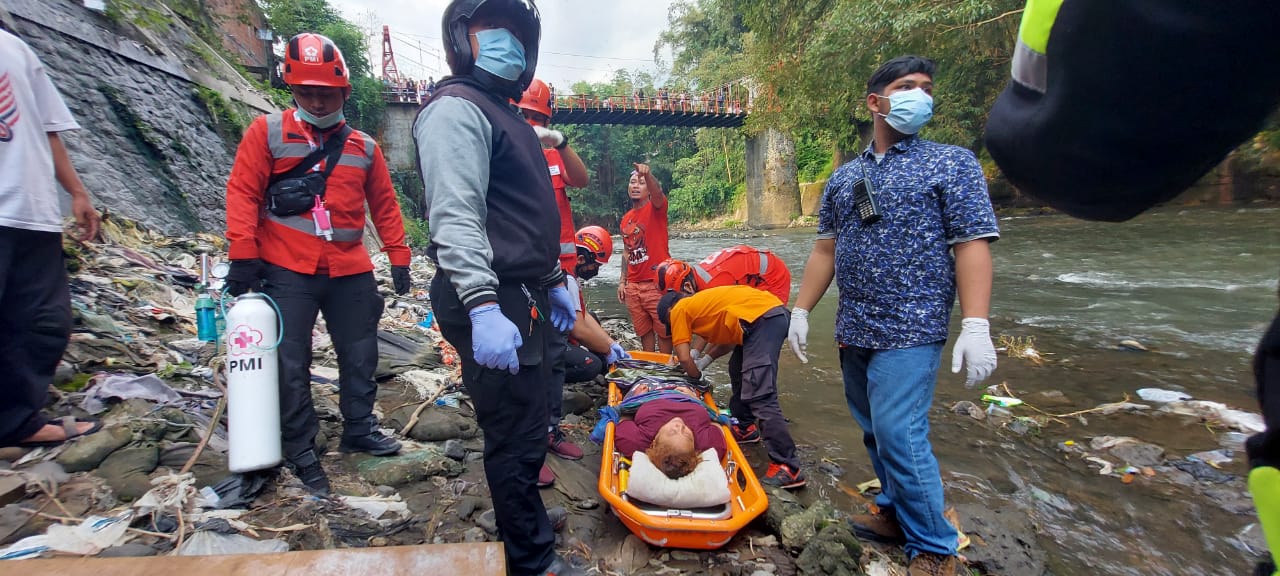 Yuyun saat dievakuasi oleh tim PMI Kota Malang. Ia jatuh ke Sungai Brantas saat hendak membuang sampah (Biyan Mudzaky / Radar Malang)