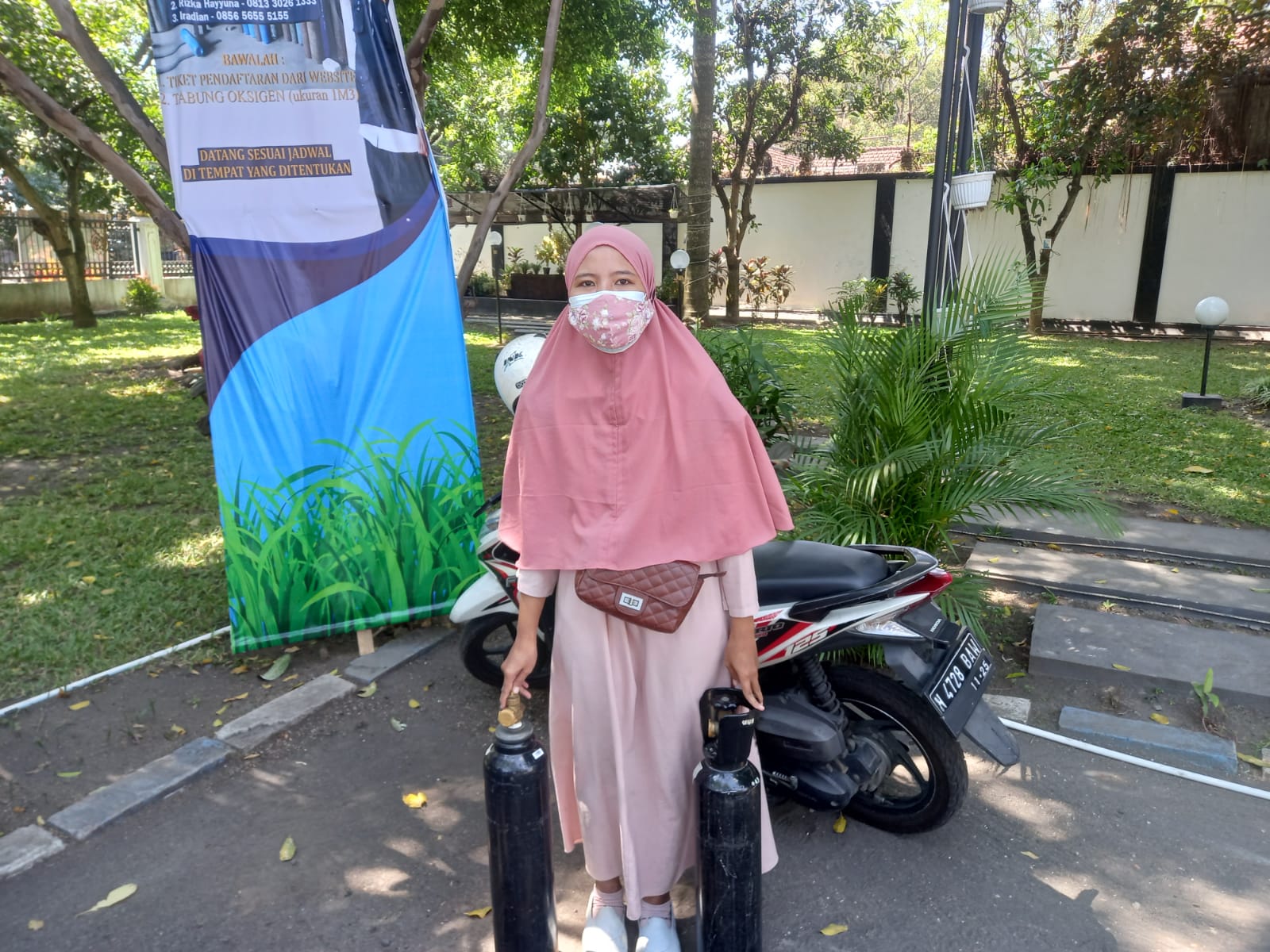 Qorry Ainah saat mengisi ulang oksigen gratis di Bakorwil Malang untuk ayahnya yang menderita stroke dan menjalani isoman. (Andika/Radar Malang)