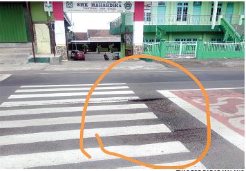 Jalan berlubang di depan SMK Mahardika (Tyas/ist)