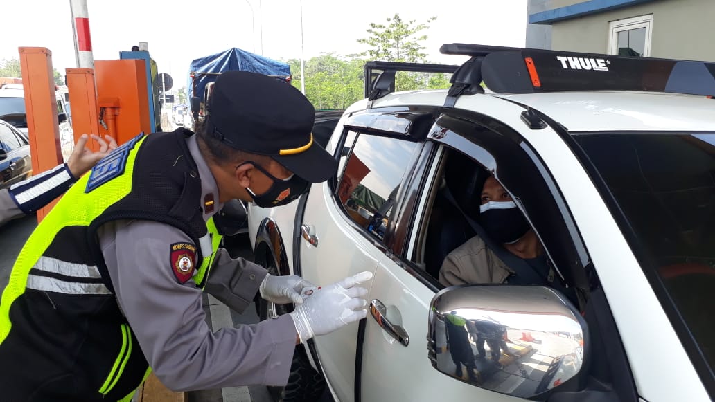 Petugas melakukan pemeriksaan kepada pengendara yang hendak masuk ke wilayah Malang.(Ubaidillah/Radar Malang)
