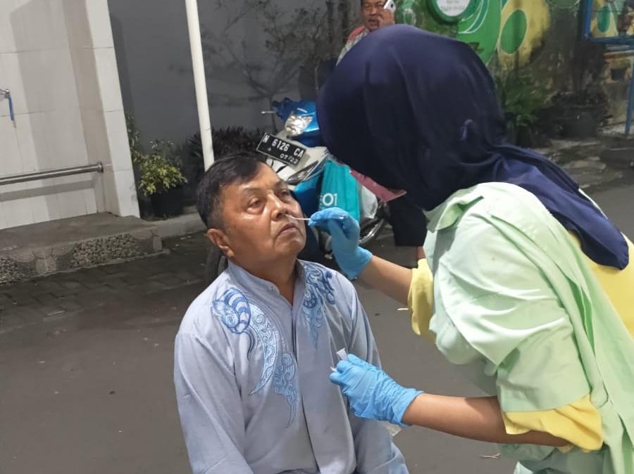 Nakes melakukan tes swab kepada salah seorang panitia kurban Kelurahan Tasikmadu (Ubadillah/Radar Malang)