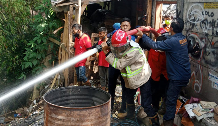 KEBAKARAN: Tim Pemadam Kebakaran (PMK) Kabupaten Malang memadamkan kobaran api di gudang PO Bagong. Achmad Fikyansyah/Radar Kanjuruhan