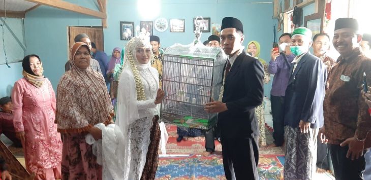 Atini, pengantin perempuan dari Purwakarta saat menerima mask kawin sangkar burung dari pengantin pria bernama Andi dari Wonosobo Jawa Tengah. (ist)