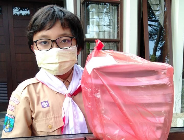 Salah satu siswa SMP Brawijaya Smart School (BSS) Malang saat menerima buku pendamping yang dikirimkan langsung ke rumah wali murid. (ist)