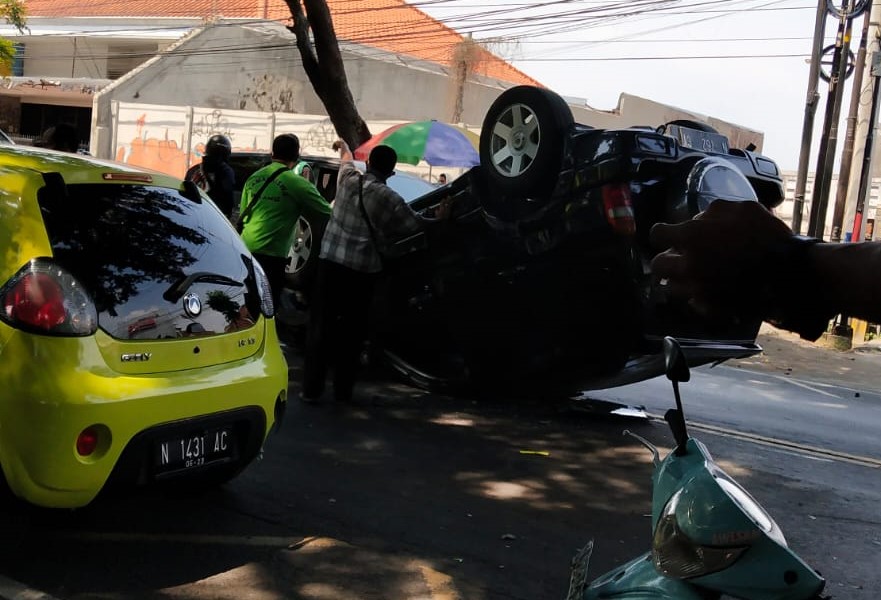 Kondisi mobil Suzuki Escudo yang terbalik di Jalan Tumenggung Suryo, Kelurahan Purwantoro, Kecamatan Blimbing Kamis siang (5/8). (Relawan Malang Raya/ist)