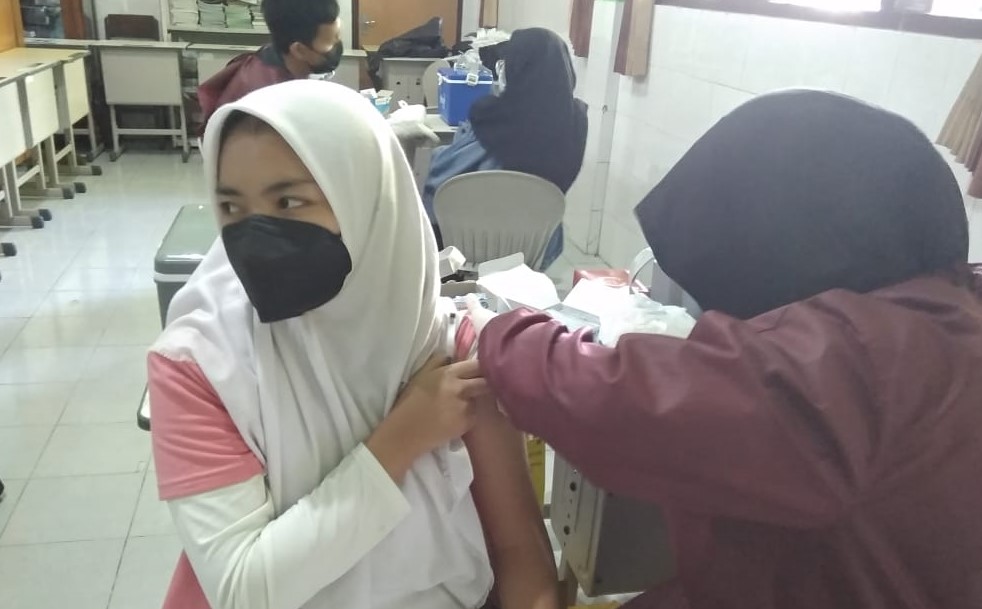 Ilustrasi pelajar SMAN 2 Malang saat disuntik vaksin oleh nakes. (Roisa/Radar Malang)