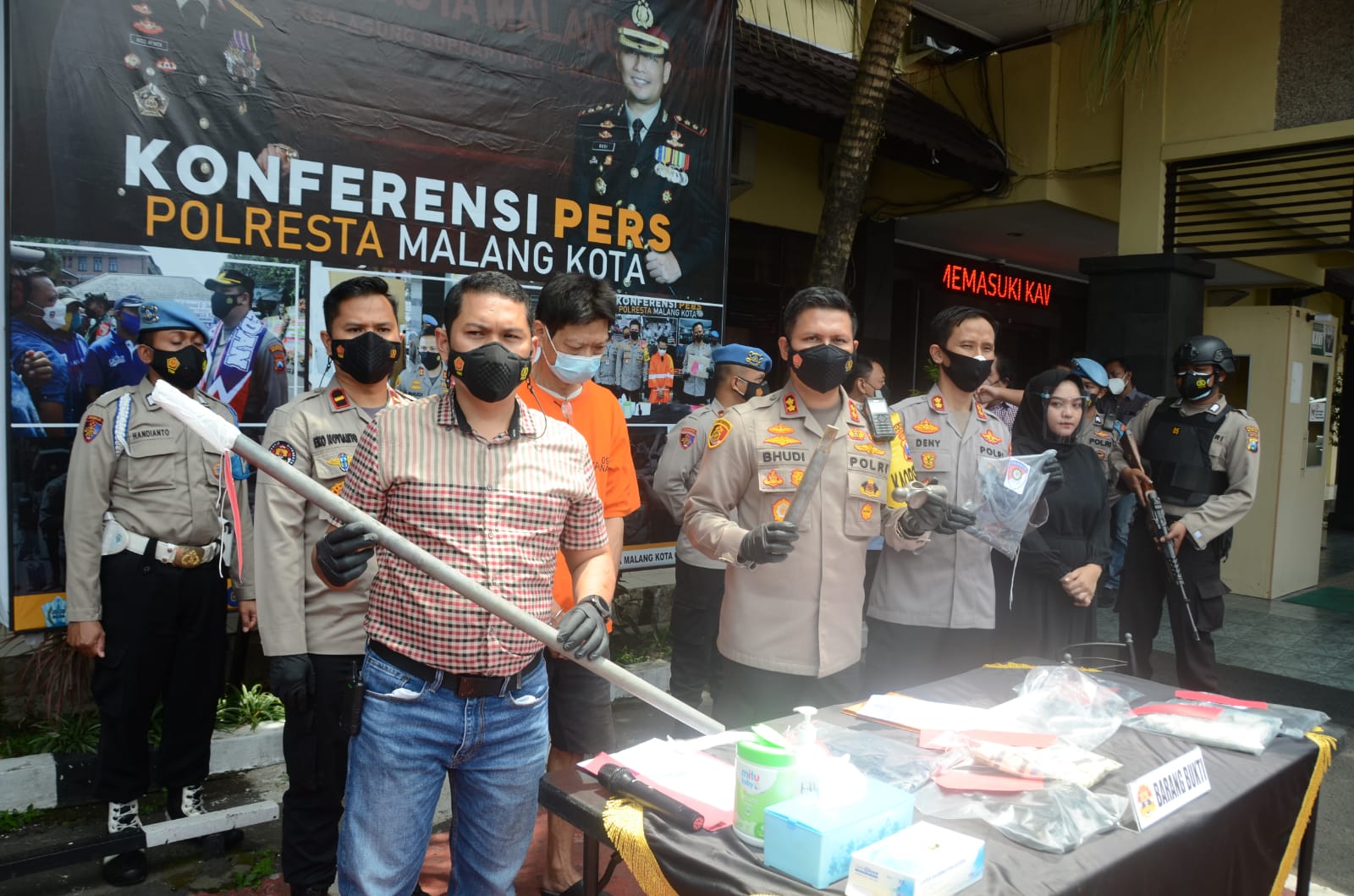 Kasat Reskrim Polresta Malang Kota Kompol Tinton Yudha Riambodo menunjukkan barang bukti pipa yang digunakan pelaku pembunuhan mengunci TKP dari luar. (biyan/Radar Malang)