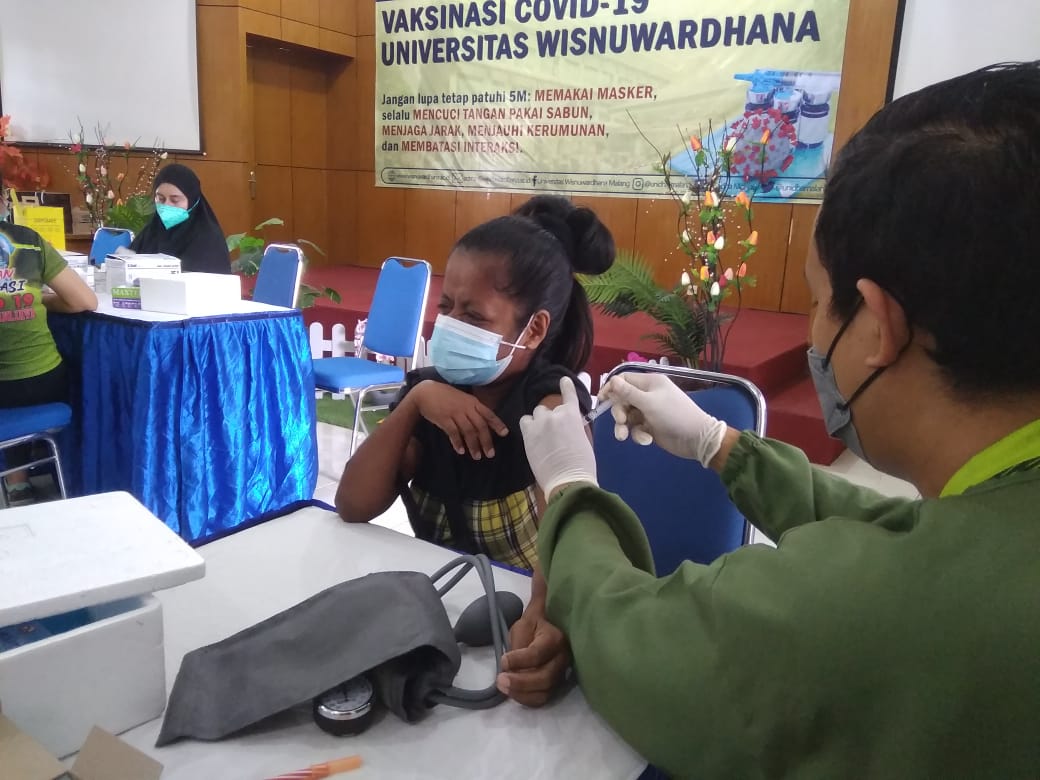 Seorang mahasiswa mendapat suntikan vaksin di Universitas Wisnuwardhana, Kamis (30/9). (Roisyatul/Radar Malang)