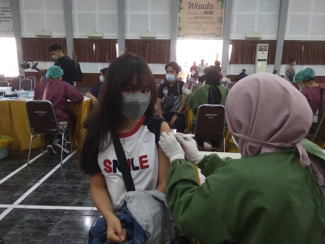 Mahasiswi Unikama mendapat suntikan vaksin Covid-19 di Aula Sarwakirti Unikama Selasa (28/9). (Roisyatul/Radar Malang)