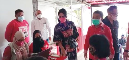 Krisdayanti bersama Ketua DPC PDIP Kota Batu Punjul Santoso saat menghadiri kegiatan vaksinasi yang digelar DPC PDI Perjuangan Kota Batu, Sabtu (25/9). (Suharto/Radar Malang)