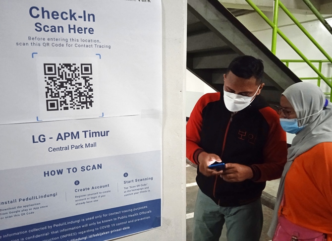 Pengunjung mal saat melakukan scan QR code untuk mengakses kartu vaksin sebelum memasukin pusat perbelanjaan Mall Central Park, Jakarta, Kamis (12/8/2021). (Dery Ridwansah/Jawapos/ist)