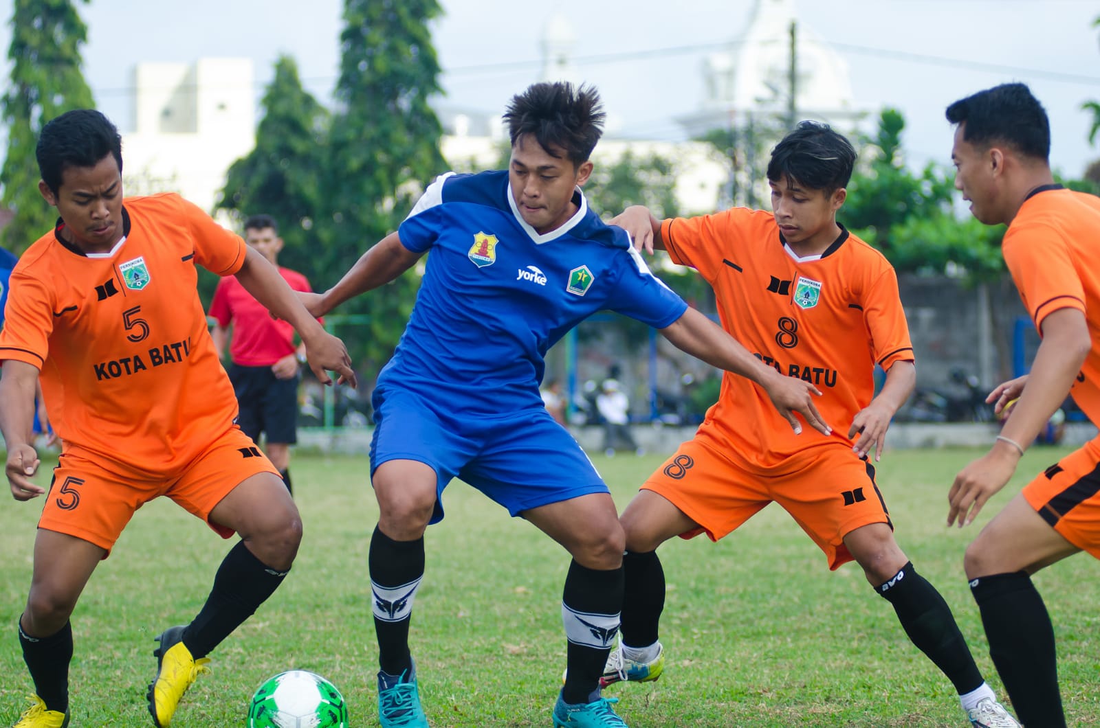 Pemain Persema Malang (jersey biru) dikepung tiga pemain Persikoba Batu di Liga 3. (Andika Satria/Radar Malang)