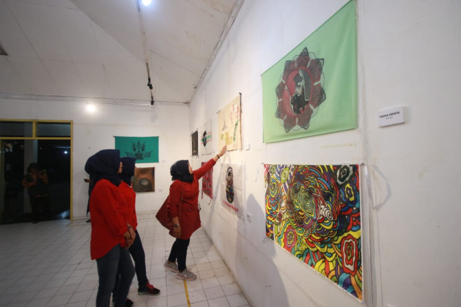 Pengunjung menikmati pameran art flag di gedung DKM Kota Malang. (Suharto/Radar Malang)
