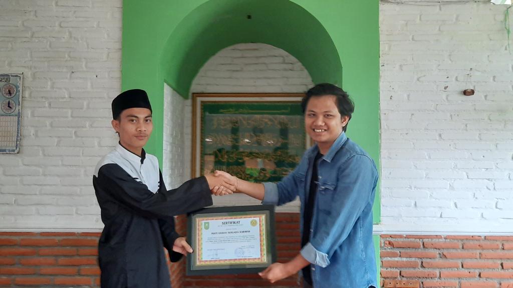 Ketua Umum IKPMR Malang Manja Herawja (kanan) memberikan donasi secara simbolis kepada perwakilan panti asuhan.