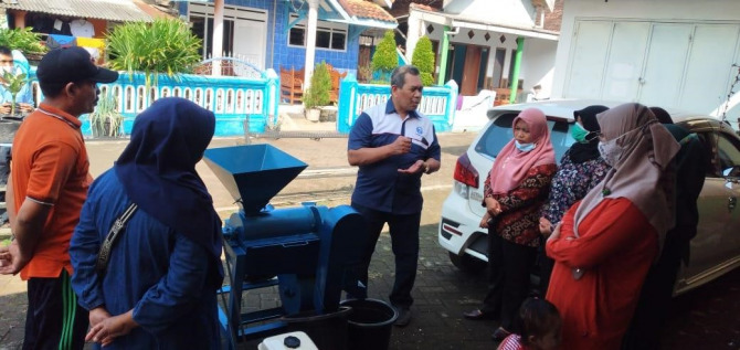 Prof. Dr. Muhammad Alfian Mizar, MP sedang menjelaskan pengaplikasian mesin pengupas biji kopi kepada warga petani kopi di Desa Srigading, Lawang.