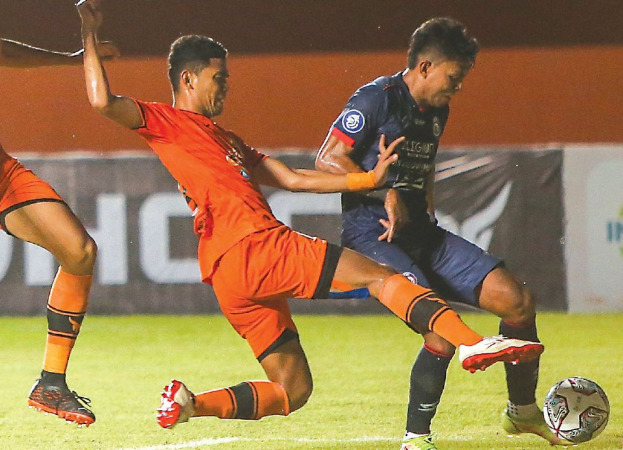 Dedik Setiawan ditempel bek kanan Persiraja Banda Aceh M. Rifaldi dalam laga di Stadion Maguwoharjo, Sleman, Sabtu malam lalu (23/10). Pertandingan itu dimenangkan Arema FC dengan skor 0-2. (Riana Setiawan/Radar Malang)