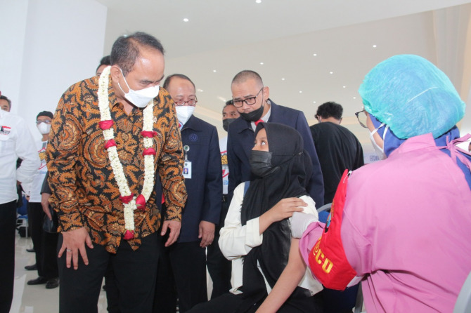 Wakil Menteri Desa, Pembangunan Daerah Tertinggal dan Transmigrasi RI, Budi Arie Setiadi (baju batik) berbincang dengan peserta vaksinasi ditemani oleh Rektor UWG Dr Agus Tugas Sudjianto ST MT (Rofia/Radar Malang)