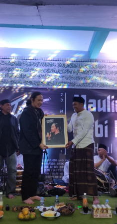 Gus Taqin pengasuh ponpes Al Ghozali (kanan) memberikan kenang-kenangan lukisan ke Gus Sabrang.