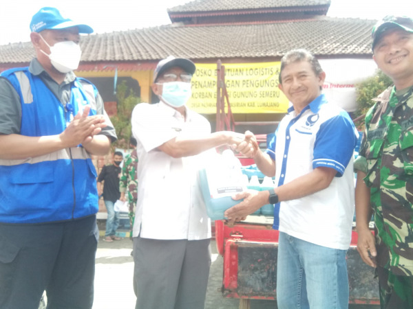 BANTU RELAWAN: Wakil Ketua Hiswana Migas Herdianto (kanan) secara simbolis menyerahkan bantuan pertamax ke Kades Pasirian Ir Sugeng, Rabu (29/12/21). (ABDUL MUNTHOLIB/RADAR MALANG)