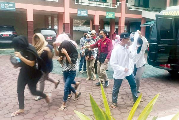 HUKUMAN RINGAN: YG (berpeci hitam), terdakwa kasus pemerkosaan bersama terdakwa lain menjelang sidang vonis di PN Kota Malang kemarin sore (23/12). (suharto/radar malang)